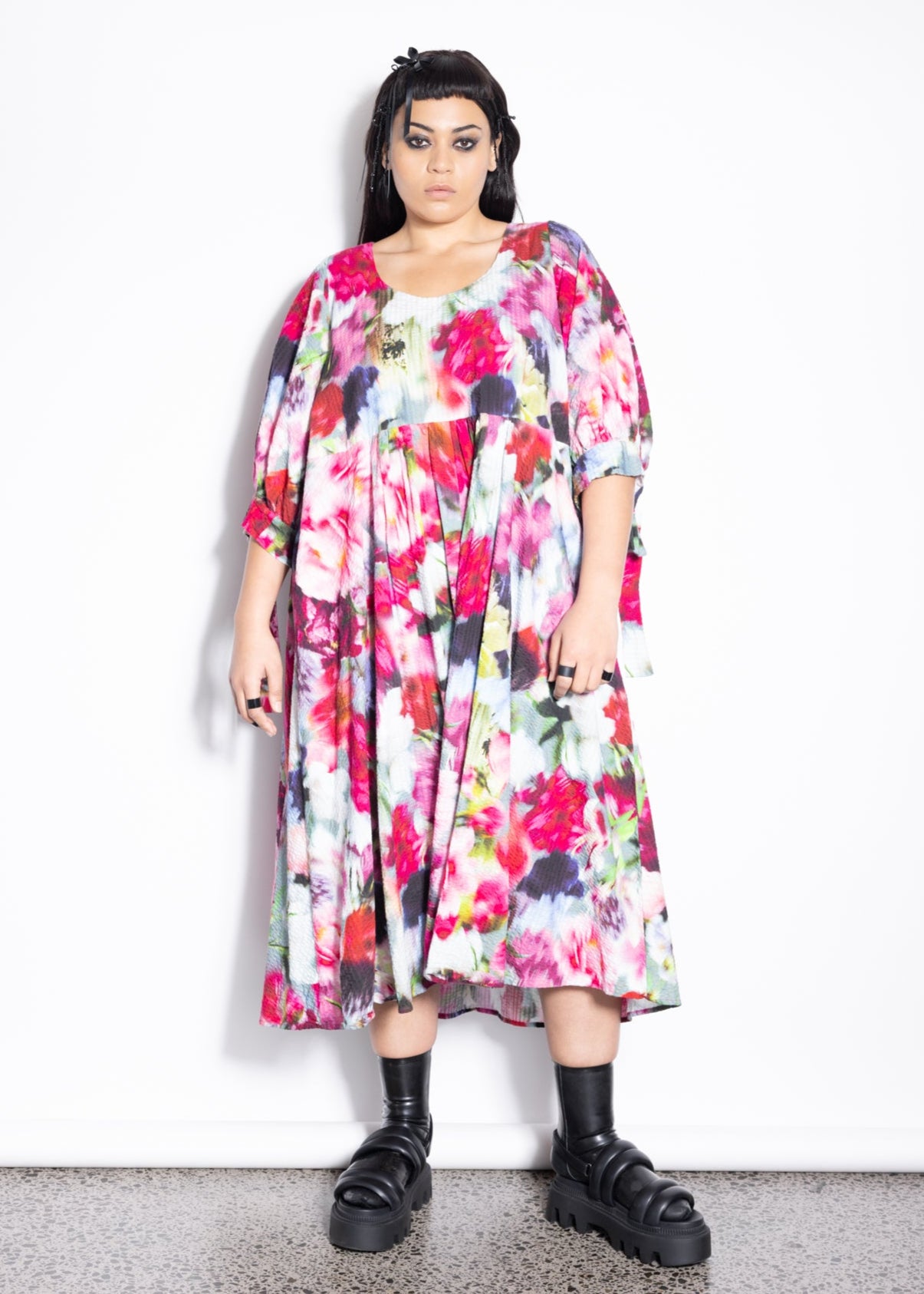 Person wearing a colorful floral dress on a white background